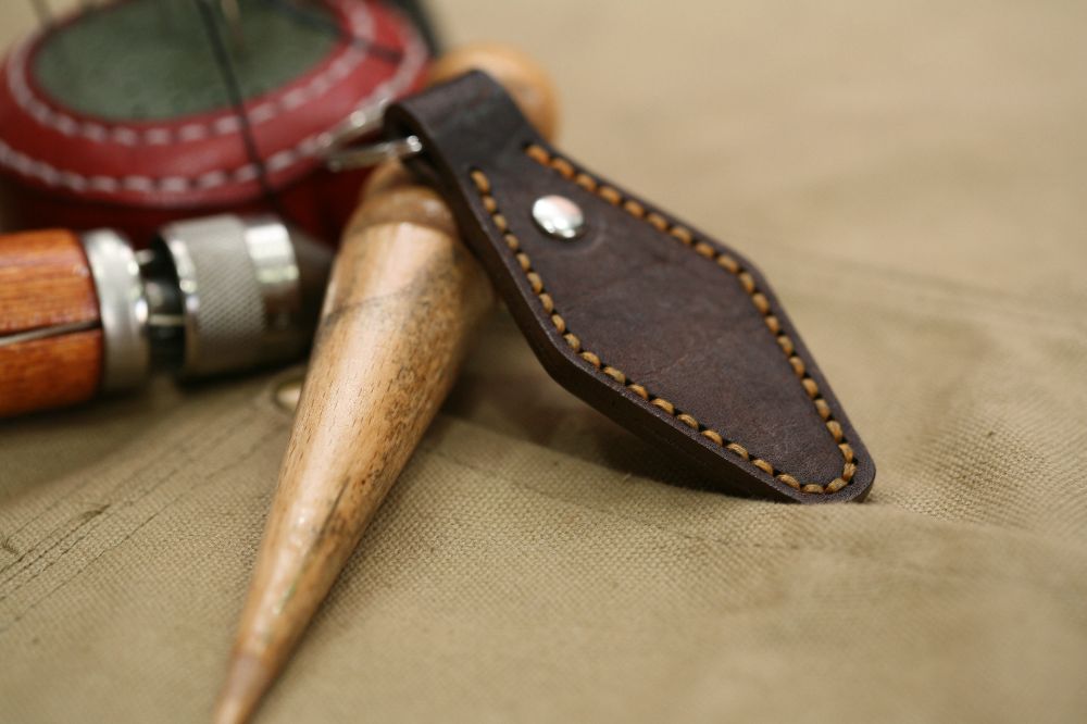 Handcrafted leather keyring with detailed stitching, available in brown and other colours