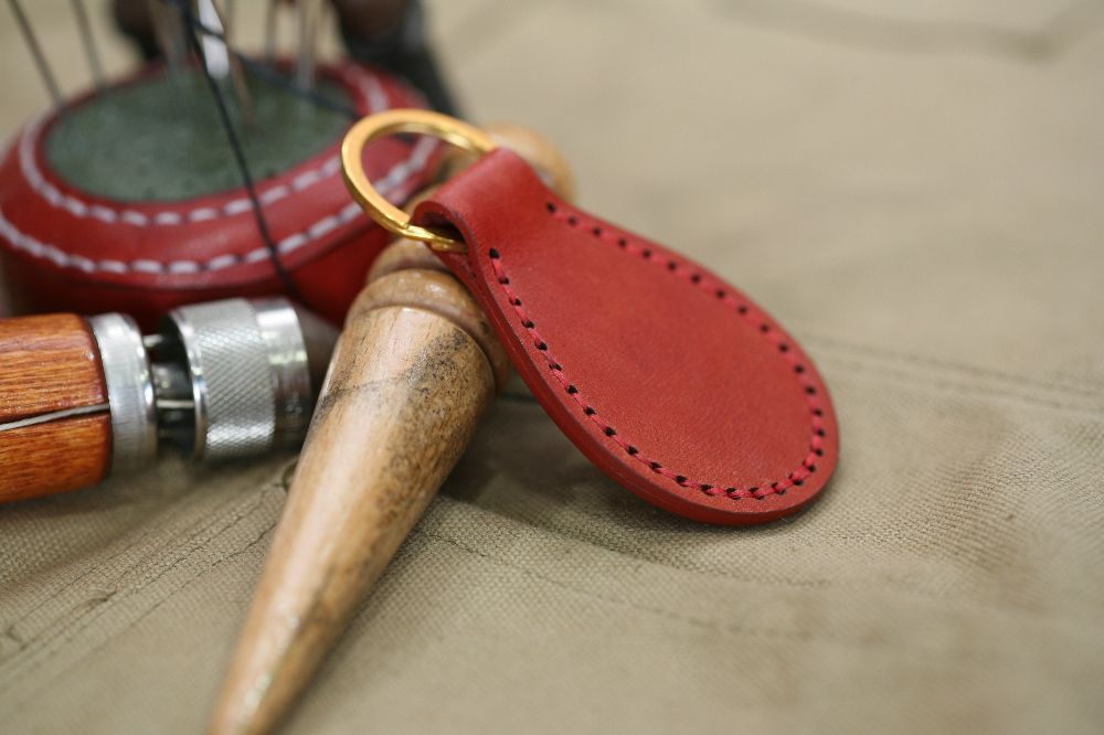 Handcrafted leather keyring with detailed stitching, available in brown and other colours